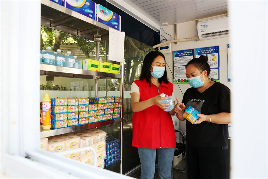 在生活垃圾分類服務驛站，管理員（左）給市民兌現垃圾分類積分制實物。楊敏攝