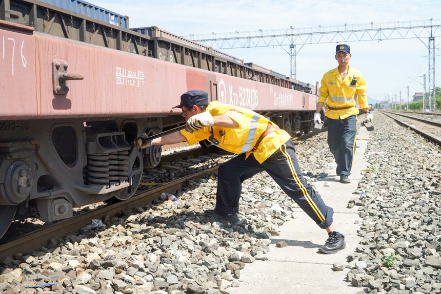 8月9日，重慶西車輛段貨車檢車員正在處置中歐班列閘瓦故障。劉彪攝