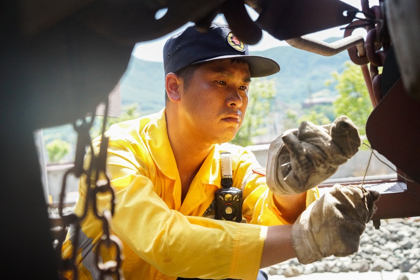 8月9日，重慶西車輛段貨車檢車員正在捆綁中歐班列人力制動機鏈。劉彪攝