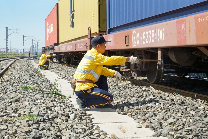 8月9日，重慶西車輛段貨車檢車員正在確認中歐班列制動缸狀態(tài)。劉彪攝