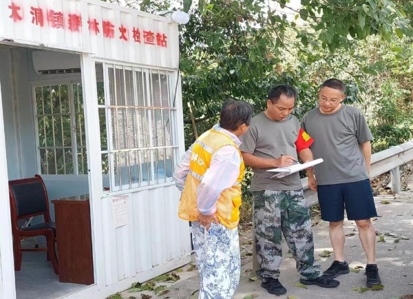 鎮(zhèn)主要領導每日巡查森林防火守卡點并檢查登記薄。木洞鎮(zhèn)供圖