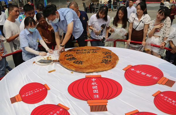 游客品嘗巨無(wú)霸榨菜月餅。楊孝永攝