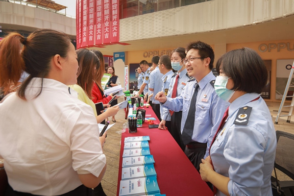 近日，在巫山縣個體工商戶服務(wù)月活動中，稅務(wù)人員向市民介紹稅費優(yōu)惠政策。甘磊攝