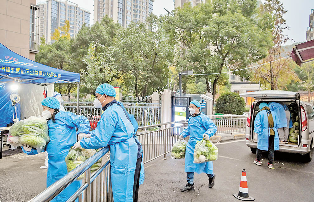 配送 順利到達！渝北區(qū)三社融合公司工作人員將蔬菜包交到下單購買的居民手中。