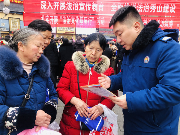 秀山縣消防救援大隊(duì)宣傳員田濤（右一）正為市民宣傳消防安全知識(shí)。楊帆攝