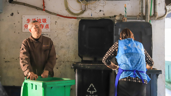 趙波幫助母親陳正群搬運(yùn)垃圾桶。菜園壩街道供圖