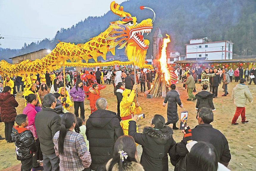 二月七日，彭水縣太原鎮(zhèn)花園村，村民和游客觀看舞龍表演。當(dāng)日，太原鎮(zhèn)各村組開展寫春聯(lián)、猜燈謎、舞龍舞獅等傳統(tǒng)活動，營造了濃濃的節(jié)日氛圍。特約攝影 趙勇\視覺重慶