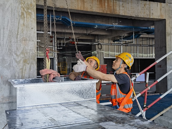 建筑工人正在進(jìn)行機(jī)電風(fēng)管安裝作業(yè)。中建八局供圖