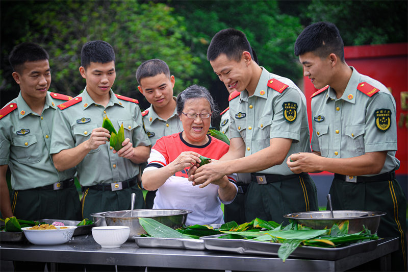 “兵媽媽”陳莉萍與武警官兵一起包粽子。郭傳武攝