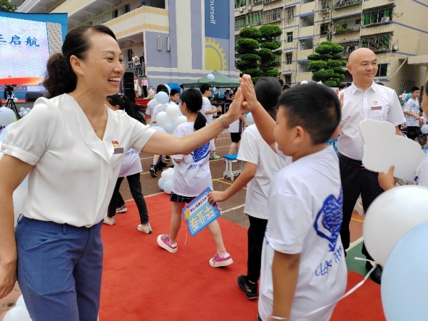 畢業(yè)禮上，黨員教師和孩子們擊掌。豐都縣濱江小學校供圖