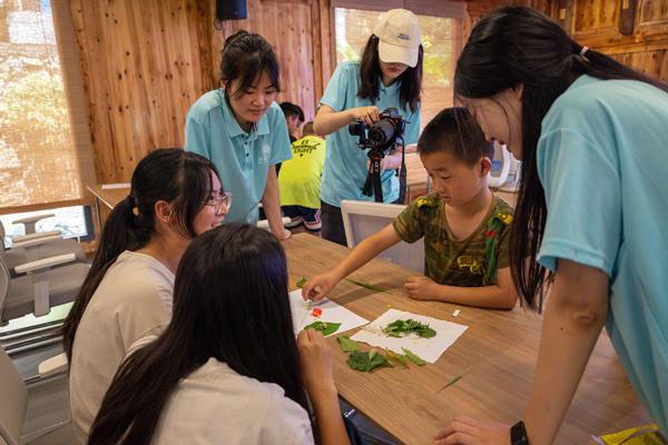 小分隊(duì)成員與小朋友們共同繪制花草貼畫。西南大學(xué)供圖